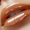  a high shine caramel nude lip gloss with warm beige undertone creamy slightly opaque finish with fine gold shimmer