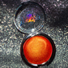 Shimmering molten tangerine golden chrome highlighter makeup compact with 'mocha made cosmetics' branding on a glittery background