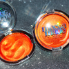 Shimmering molten tangerine golden chrome highlighter makeup compact with 'mocha made cosmetics' branding on a glittery background