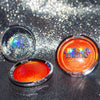 Shimmering molten tangerine golden chrome highlighter makeup compact with 'mocha made cosmetics' branding on a glittery background